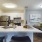 kitchen with white cabinets and wine glasses on counter next to a dining space 